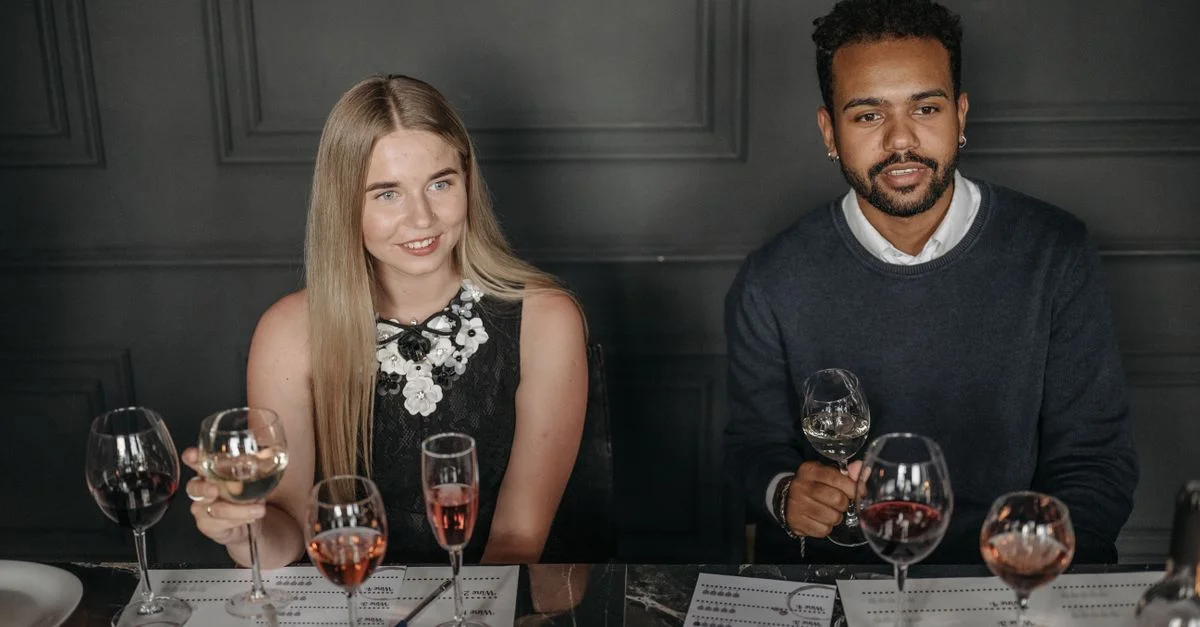 Deux adultes profitant d'une séance de dégustation de vin dans un cadre intérieur sophistiqué.