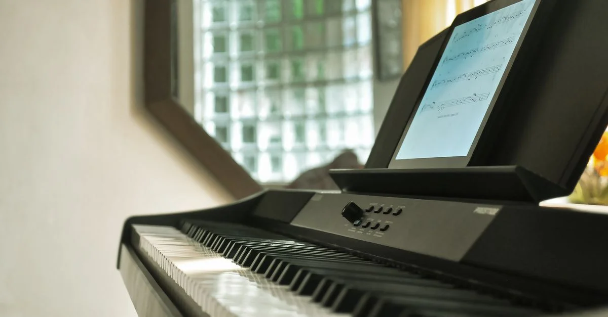 Gros plan sur un piano numérique avec un affichage de partitions dans une pièce bien éclairée.